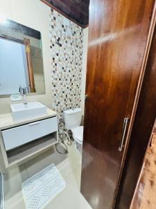 a bathroom with a toilet and a sink and a wooden door at Aeroporto de Guarulhos in Guarulhos +25 photos
