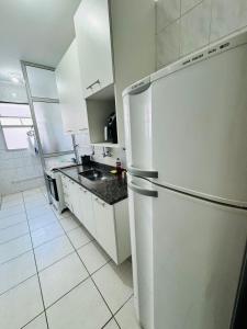a white kitchen with a refrigerator and a sink at Aeroporto de Guarulhos in Guarulhos