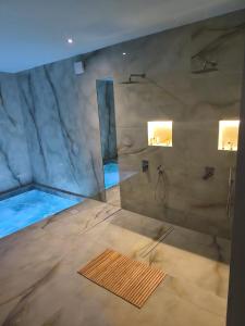 a large bathroom with a shower and a tub at Aianteio Square Resort -SPA in Aiándion