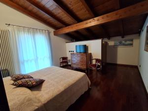 a bedroom with a bed and a dresser and a television at B&b Villa Giò in Cremeno +25 photos