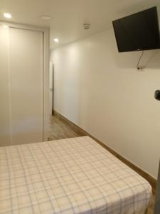ein Zimmer mit einem Bett und einem Flachbildfernseher in der Unterkunft Hotel Skyline Boadilla in Alcorcón