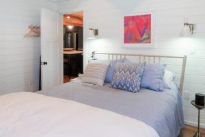 a white bed with blue pillows in a bedroom at Lake Winni Cottage in Moultonborough
