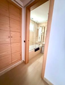 a bathroom with wooden cabinets and a walk in closet at SunGolf Apartment in Los Alcázares +23 photos
