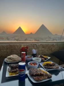 a table with plates of food with pyramids in the background at Sun Hotel in Cairo +16 photos