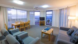 a living room with a couch and a table and a dining room at Beach House Seaside Resort in Gold Coast