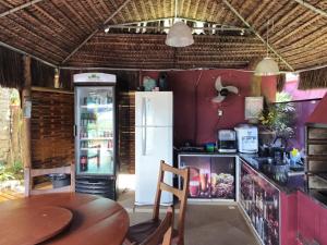 a kitchen with a table and a refrigerator at Studio Moderno com Vista pro mar com hidromassagem e churrasqueira privativas e Piscina aquecida na área comum in São Sebastião