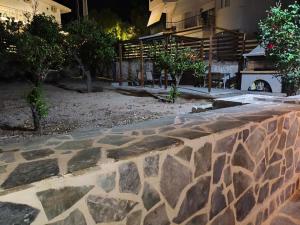 a stone retaining wall in front of a building at Aianteio Square Resort -SPA in Aiándion