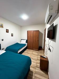 a hotel room with two beds and a flat screen tv at The Rivénto Boutique with Breakfast - Downtown,Cairo in Cairo