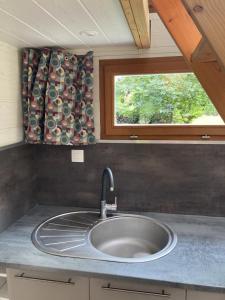 a kitchen counter with a sink and a window at Tiny House Insolite avec Escape Game in Chanzeaux +55 photos