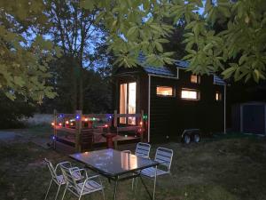 a table and chairs in front of a tiny house at Tiny House Insolite avec Escape Game in Chanzeaux
