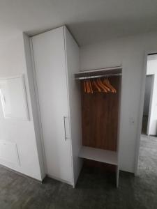 a closet with white walls and a wooden cabinet at Zimmer 2, Haus der Begegnung in Goldingen