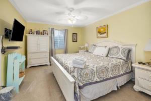 a bedroom with a bed and a television in it at Ocean Walk H-14 in Saint Simons Island +32 photos