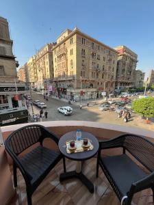 a table and chairs on a balcony with a city street at The Rivénto Boutique with Breakfast - Downtown,Cairo in Cairo