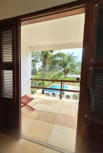 a room with a view of a patio with palm trees at Vila Saguaro in Flecheiras