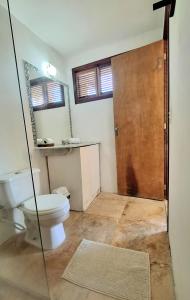 a bathroom with a toilet and a mirror at Vila Saguaro in Flecheiras +60 photos