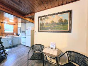 a kitchen with a table and chairs and a painting on the wall at #08 - One Bedroom Lakeview Cottage-Pet Friendly in Hot Springs +23 photos