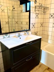 a bathroom with a sink and a mirror and a tub at Cabane La Folie Douce in Hotton +29 photos