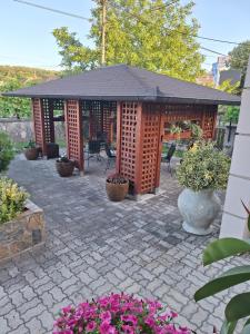 a patio with a pavilion with flowers and plants at Apartmani Radulović in Vrnjačka Banja