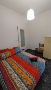 a bedroom with a bed with a colorful blanket at Tamika's House in Udine +6 photos