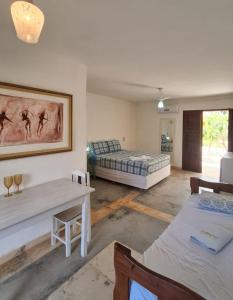 a living room with two beds and a table at Vila Saguaro in Flecheiras