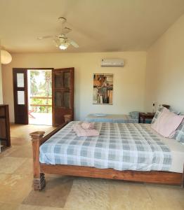 a bedroom with a bed with a blue and white checkered blanket at Vila Saguaro in Flecheiras