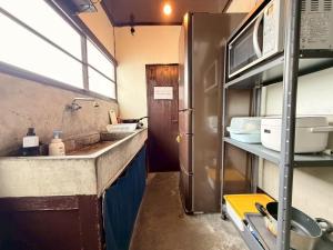 a kitchen with a sink and a refrigerator at ura Yadokari House in Okayama
