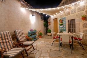a patio with chairs and a table and lights at Casa Rural El Berrueco in Robledillo