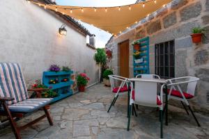a patio with chairs and a table in a courtyard at Casa Rural El Berrueco in Robledillo