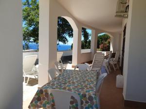 a table and chairs on a patio with a view of the ocean at Capomare2 in Capo Vaticano