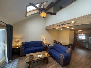 a living room with two blue couches and a ceiling fan at Mountain Home at Camelback in Tannersville