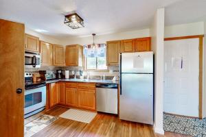 a kitchen with wooden cabinets and a white refrigerator at Mountain Home at Camelback in Tannersville +28 photos