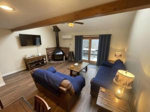 a living room with a blue couch and a fireplace at Mountain Home at Camelback in Tannersville