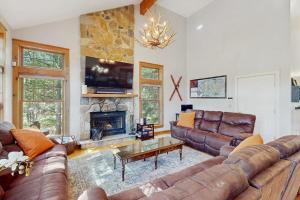 a living room with leather couches and a fireplace at Vista at Camelback Mountain in Tannersville