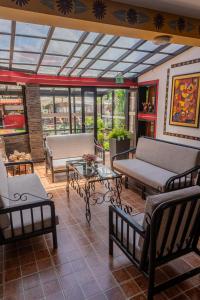a living room with couches and tables and windows at Tika Wasi Casa Boutique in Cusco