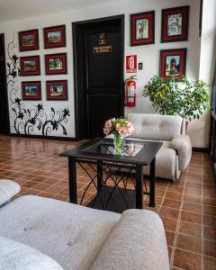 a living room with couches and a table with flowers on it at Tika Wasi Casa Boutique in Cusco