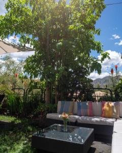 a couch and a table in front of a tree at Tika Wasi Casa Boutique in Cusco +53 photos