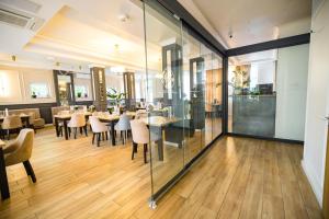 a restaurant with glass walls and tables and chairs at Nysa Gubin in Gubin