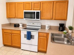 a kitchen with a white stove top oven next to a sink at See you in Orlando in Kissimmee