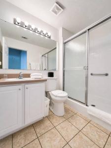 a white bathroom with a toilet and a shower at See you in Orlando in Kissimmee