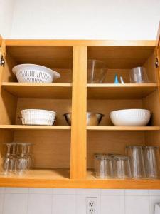 a wooden cabinet with dishes and bowls in it at See you in Orlando in Kissimmee +4 photos