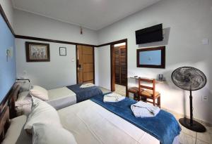 a hotel room with two beds and a fan at Hotel São Charbel in Ubatuba +194 photos