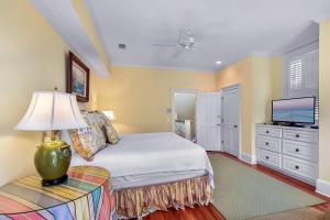 a bedroom with a bed with a lamp and a tv at Avonlea Cottage in Saint Simons Island +42 photos