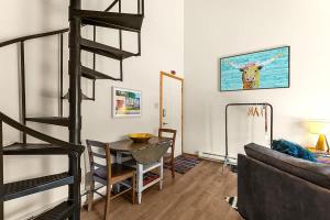 a living room with a spiral staircase and a table at Restful Rockies Overlook in Steamboat Springs
