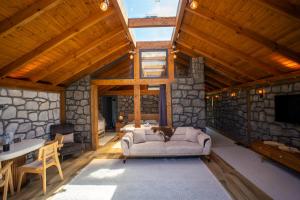 a living room with a stone wall and a couch at Modatepe Bungalow & Otel in Uğurlu