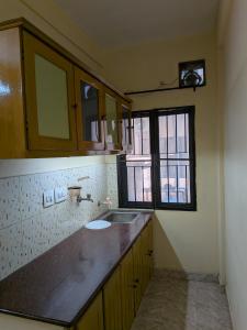 an empty kitchen with a sink and a window at JUST WALKING DISTANCE FROM Temble in Guruvāyūr