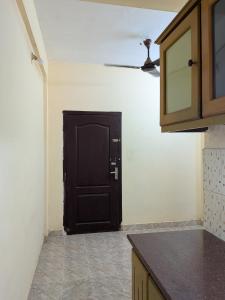 a kitchen with a black door in a room at JUST WALKING DISTANCE FROM Temble in Guruvāyūr