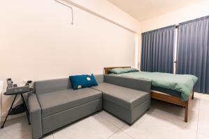 a bedroom with a couch and a bed at 日曜居Nichiyō inn in Dayuan