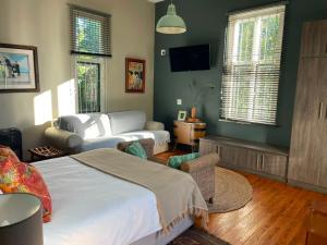 a bedroom with a bed and a couch at RHOOM in Burgersdorp