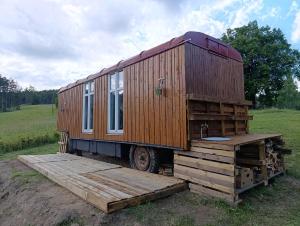 a tiny house sitting on top of a pile of wood at Útulná Maringotka in Dolní Město
