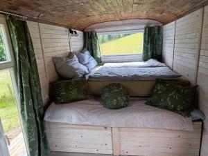 an interior of a caravan with two beds and a window at Útulná Maringotka in Dolní Město